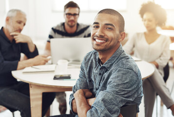 Aufkleber - My team is headed for success. Portrait of a young office worker sitting at a table with colleagues in the background.