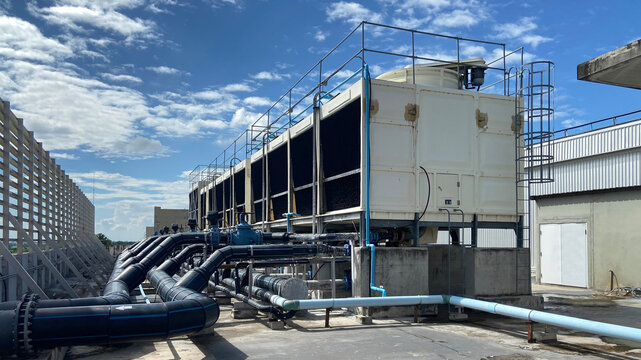 the cooling tower is located in a large data center building installed on the roof on a bright blue 