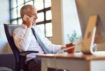 Wall Mural - Hes the man everybody wants to talk to. Shot of a mature businessman using his phone in the office.