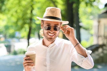 Poster - Handsome young man drinking coffee outdoors