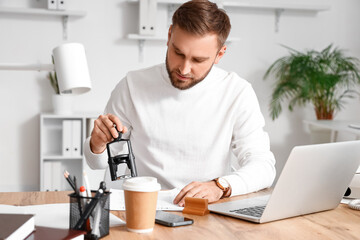 Wall Mural - Male notary public attaching seal to document in office