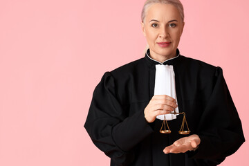 Wall Mural - Mature female judge in robe with justice scales on pink background