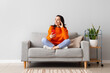 © Pixel-Shot - Beautiful young woman with mobile phone resting on couch at home