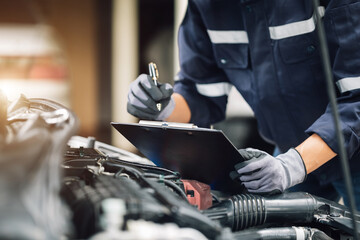 mechanic works on the engine of the car in the garage. repair service. concept of car inspection ser