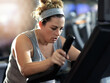Push yourself and keep it going. Shot of a determined looking woman working out on an elliptical machine in the gym.