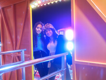 Friends Waiting On The Entrance Of A Attraction Of A Night Fair