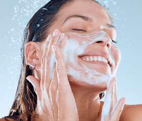 Sticker - Cleanliness will allow you to radiate with confidence. Studio shot of a young woman washing her face while taking a shower against a blue background.