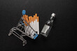 Small grocery cart with cigarettes and bottle of alcohol on back background. Top view. Purchase of tobacco products and alcoholic beverages.