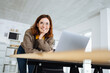 young modern business woman leaning on the desk and laughing