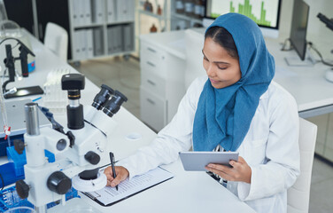 Sticker - Getting down to life enhancing lab work. Shot of a young scientist using a digital tablet while conducting research in a laboratory.