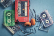 Vintage audio cassette with orange headphones and player.