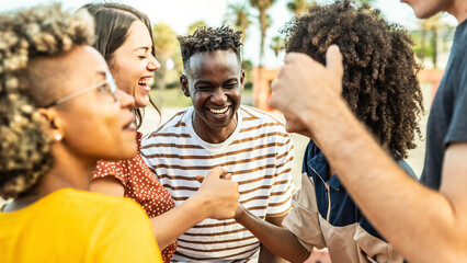 Wall Mural - Multiracial best friends having fun laughing out loud outdoors - Group of young people enjoying summertime day out - Teenagers joking together in college campus - Friendship concept