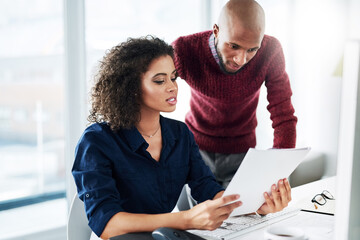 Aufkleber - I was just reading over this paperwork.... Cropped shot of a male supervisor helping an attractive young businesswoman while working in their office.