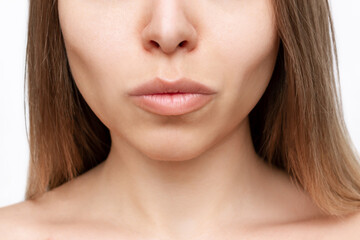 Wall Mural - Cropped shot of a young woman's lower part of the face with clear highlighted cheekbones isolated on a white background. Plastic surgery buccal fat removal. Result of cosmetic surgery