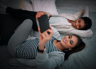 Poster - Were always selfie ready. Shot of two young women lying taking selfies while lying on a bed.