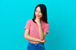 © luismolinero - Young Vietnamese woman isolated on blue background looking to the side and smiling