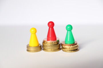 three playing figures stand on euro coins as a concept in places 1, 2 and 3 