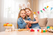 © andrey - little girls with rabbit ears play with Easter eggs in game.