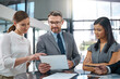 © Mapodile M/peopleimages.com - Bound in business. Cropped shot of a group of businesspeople looking over a digital tablet in the office.
