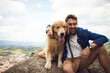 © Ruan Jordaan/peopleimages.com - The view is great from up here. Cropped portrait of a handsome young man and his dog taking a break during a hike in the mountains.