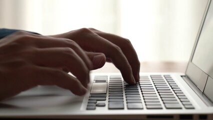 Wall Mural - businessman hand work on capable laptop computer at office table close up shot and selective focus a