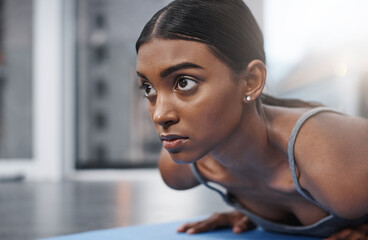 Poster - Winners never lose focus. Close up shot of an attractive young woman busy exercising on her gym mat at home.