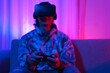 © snowing12 - Metaverse technology concept, Man wear VR goggles and use joystick to play sport games in metaverse