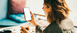 © Alex from the Rock - Woman in cafe holding blank white phone. Mockup empty background