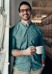 Wall Mural - Coffee is the fuel I need to keep going. Cropped portrait of a handsome young businessman smiling while holding a cup of coffee in an office.