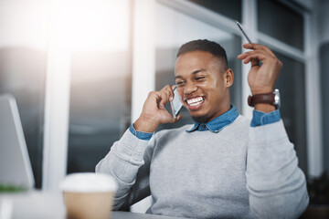 Poster - His dedication never reaches a limit. Shot of a handsome young businessman talking on a cellphone while working in an office.