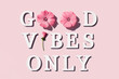 Good vibes only. Motivational quote from white letters and beauty natural flowers on pink background. Creative concept inspirational quote of the day