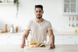 Leinwandbild Motiv Portrait of attractive young Arab guy with wholesome protein products posing at kitchen