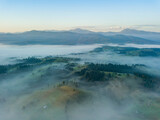 Fototapeta Góry - Green mountains of the Ukrainian Carpathians in the morning mist. Aerial drone view.
