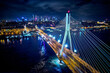 Beautiful panoramic aerial drone skyline view of the center of night Warsaw with skyscrapers in the background with the Swietokrzyski suspension bridge - the lights of the big city by night, Poland