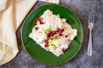 Wall Mural - Gullac dessert on dark background. Traditional Ramadan dessert. Güllaç dessert decorated with pistachio and pomegranate. Turkish cuisine delicacies. Top view