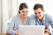 © Anne B/peopleimages.com - Searching the web together. A young couple using a laptop together at home.
