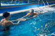 © Svitlana - Coach helping male to swim in pool