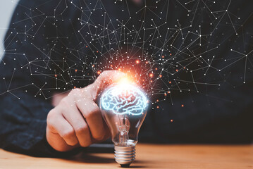 Wall Mural - Businessman hand touching lightbulb with glowing virtual brain and connection line to creative smart thinking for inspiration and innovation with network concept.