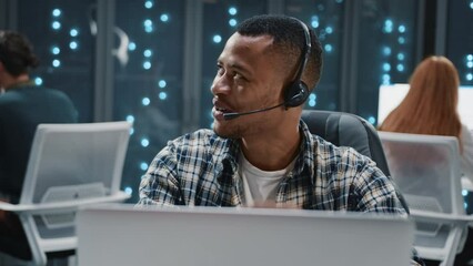 Wall Mural - african american satisfied it worker wearing headset dancing with funny colleague at workspace. comp