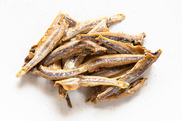 Wall Mural - handful of dried anchovy fishes close up on gray