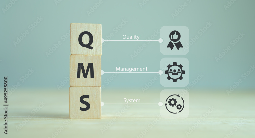 QMS, Quality management system concept. Formalized system for achieving quality policies and objectives.  ISO 9001 standard.  Wooden cubes with abbreviation of QMS and symbols on smart background.