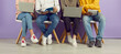 © Studio Romantic - Diverse university students in casual jeans and sneakers sitting in row, preparing assignment for class, working on laptop computer devices, sharing academic course study notes. Low section legs, feet