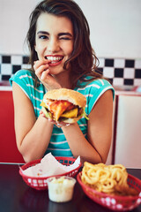 Poster - I eat very well. Cropped portrait of an attractive young woman enjoying a burger in a retro diner.