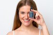 © luismolinero - Young caucasian woman isolated on white background holding a serum while smiling. Close up portrait