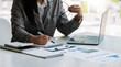 © Natee Meepian - Business woman are taking notes and using calculators and laptops on a white table. Accounting concepts