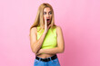 © luismolinero - Young Uruguayan blonde woman over isolated pink background whispering something with surprise gesture while looking to the side