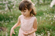 © laniko - Portrait of little girl wearing light pink dress among blooming apple trees, white flowers in hair. Living in harmony with nature concept