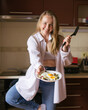 © AnnaDemy - Woman cooking breakfast on her kitchen at home. Focus on tthe Eggs on her plate.