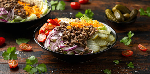 Wall Mural - Cheeseburger, hamburger or burger keto salad with beef, fresh tomatoes, red onion, pickled gherkins, lettuce and home made sauce dressing