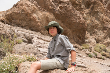 Wall Mural - Portrait of a teenager on the background of rocks.